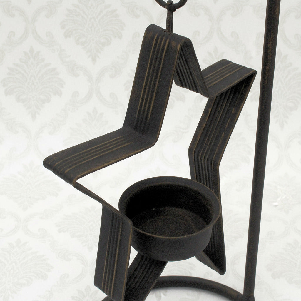 Decorative black metal candle holder with a white background