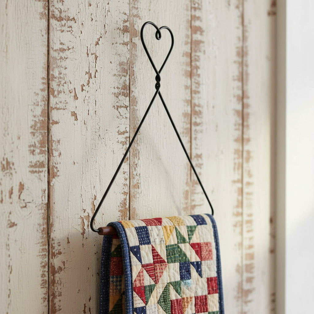 Black metal triangle-shaped hook with a heart at the top on a white background