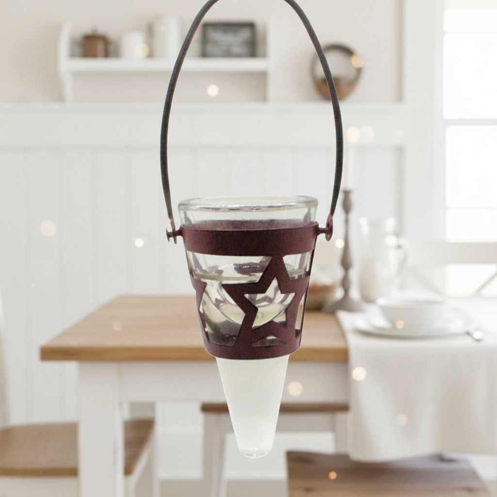 Star-patterned glass lantern with metal handle on a white background