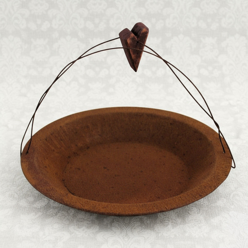 Rusty tin candle pan with wooden heart