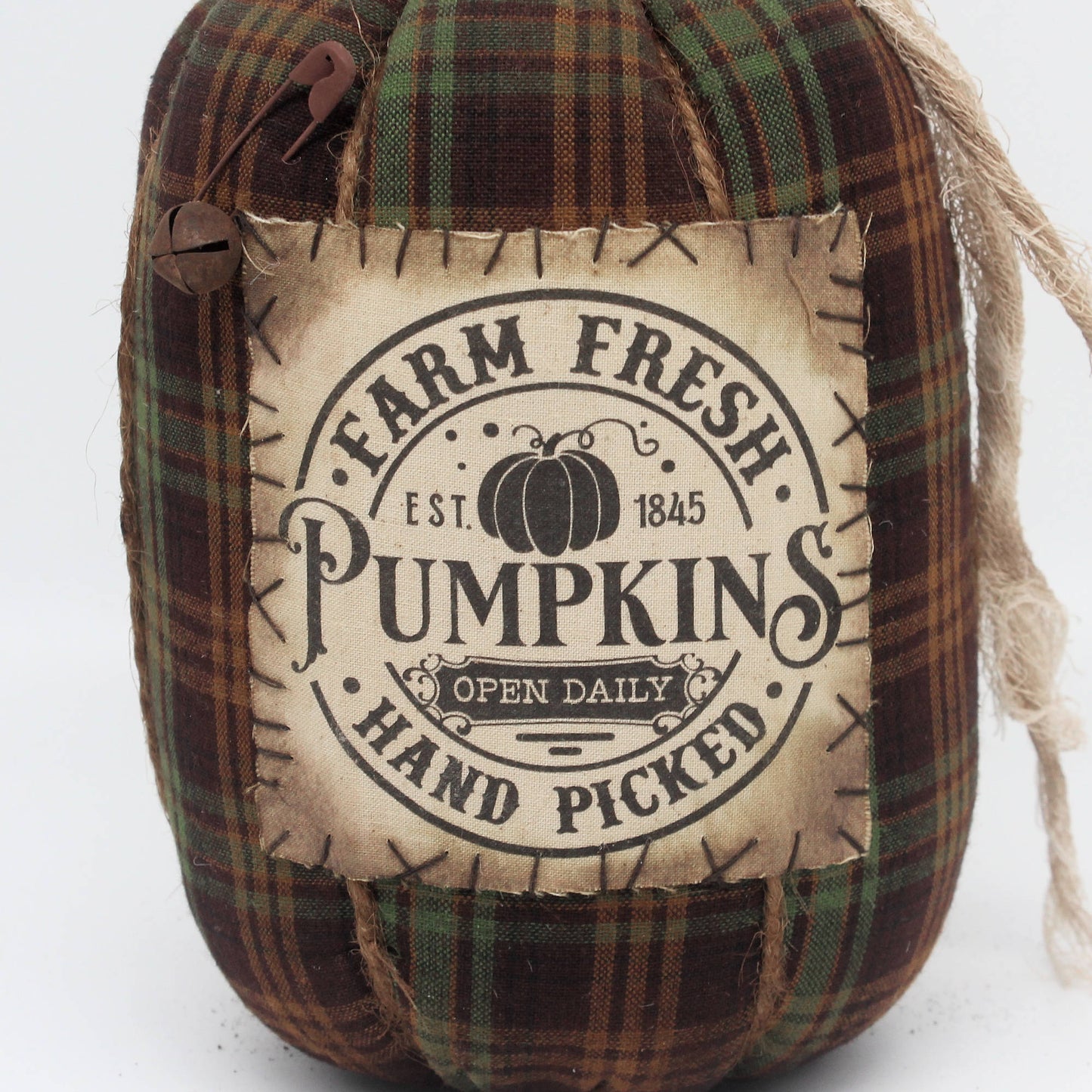 Decorative grungy homespun fabric pumpkin with plaid pattern and 'Farm Fresh Pumpkins' label on a white background