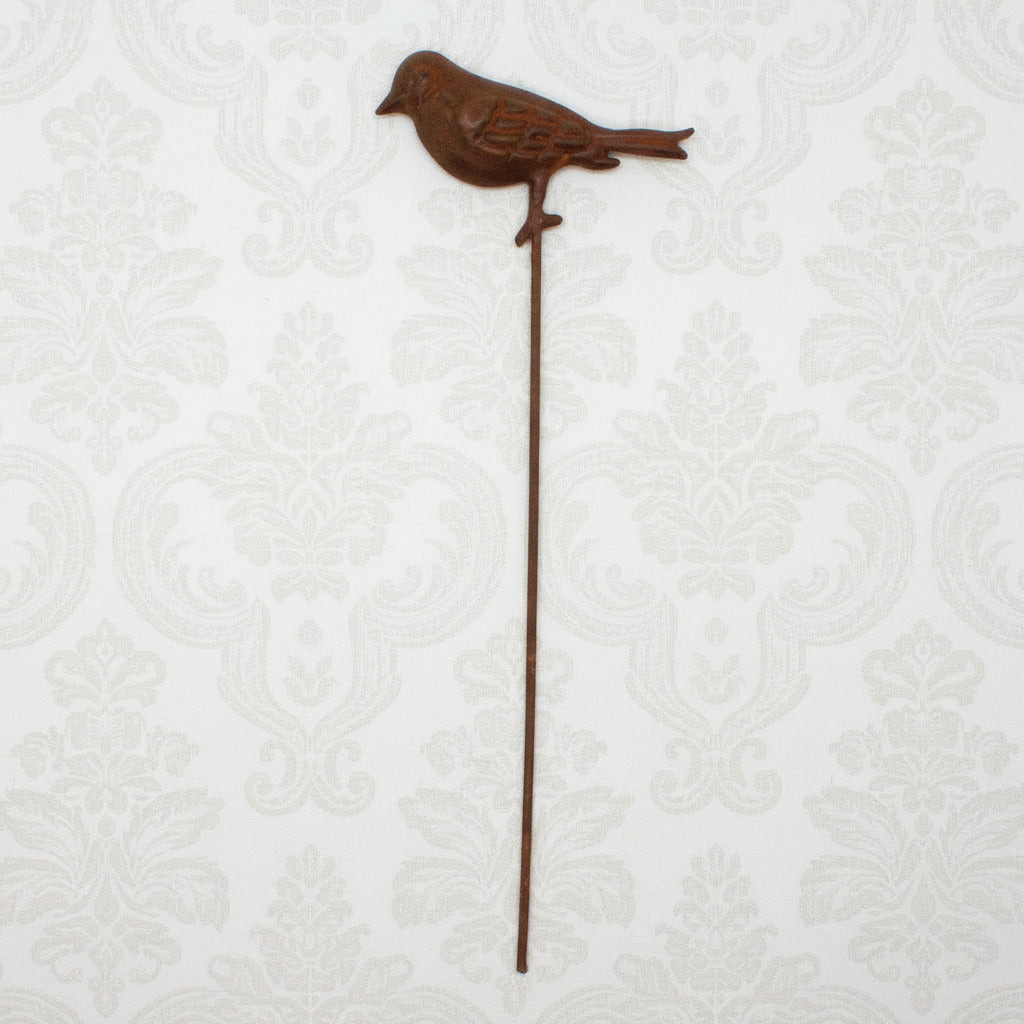 Decorative metal bird stake on a white background