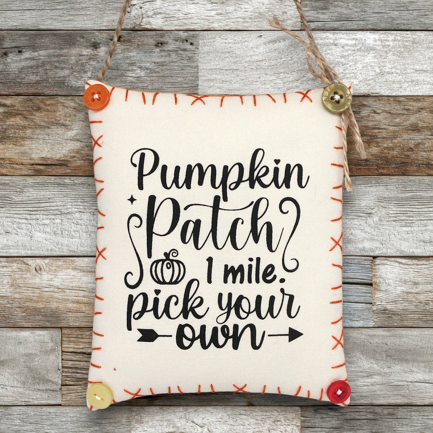 Fabric sign ornament with 'Pumpkin Patch 1 mile. Pick your own' text on a wooden background