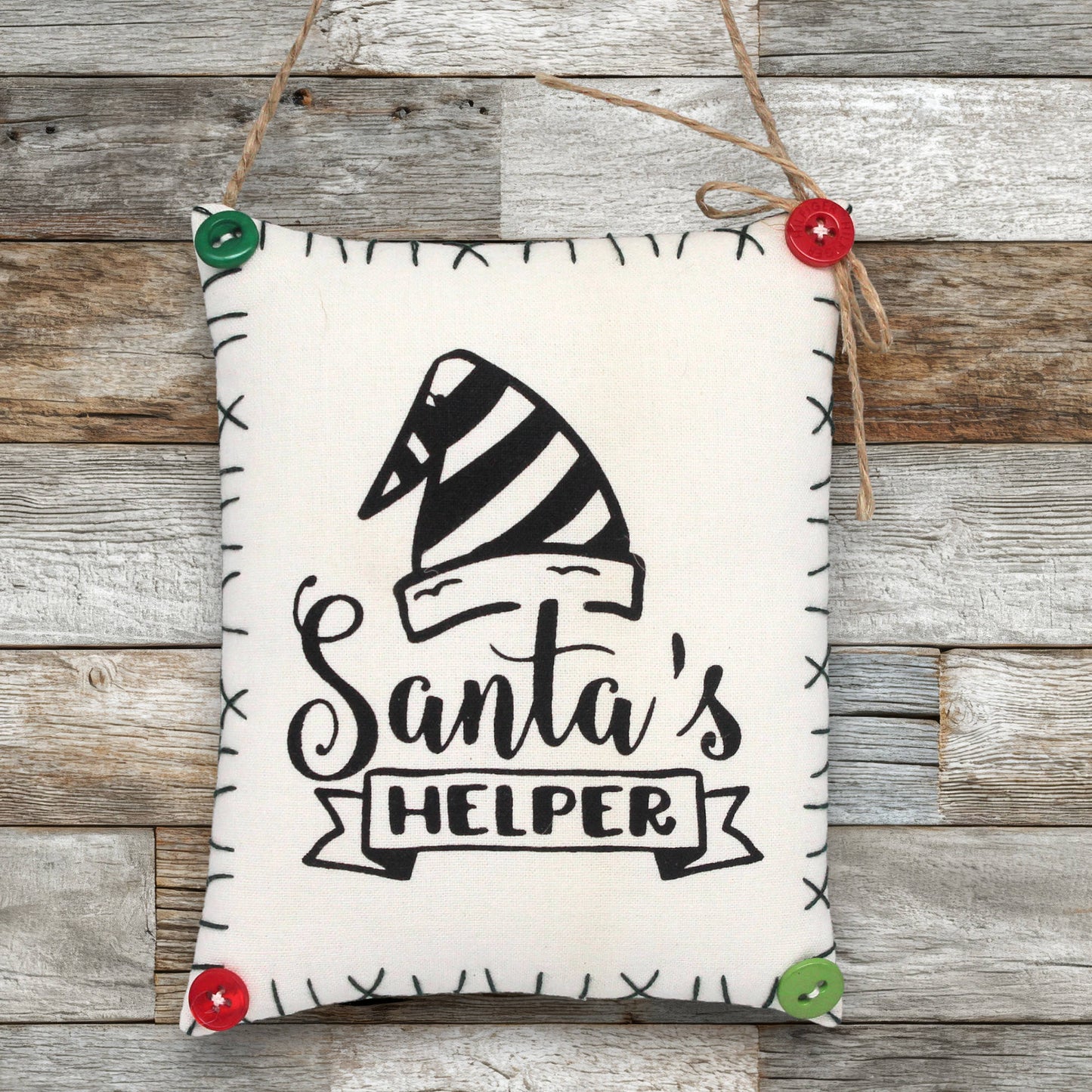 Ornament sign with 'Santa's Helper' text and a striped hat design on a wooden background.