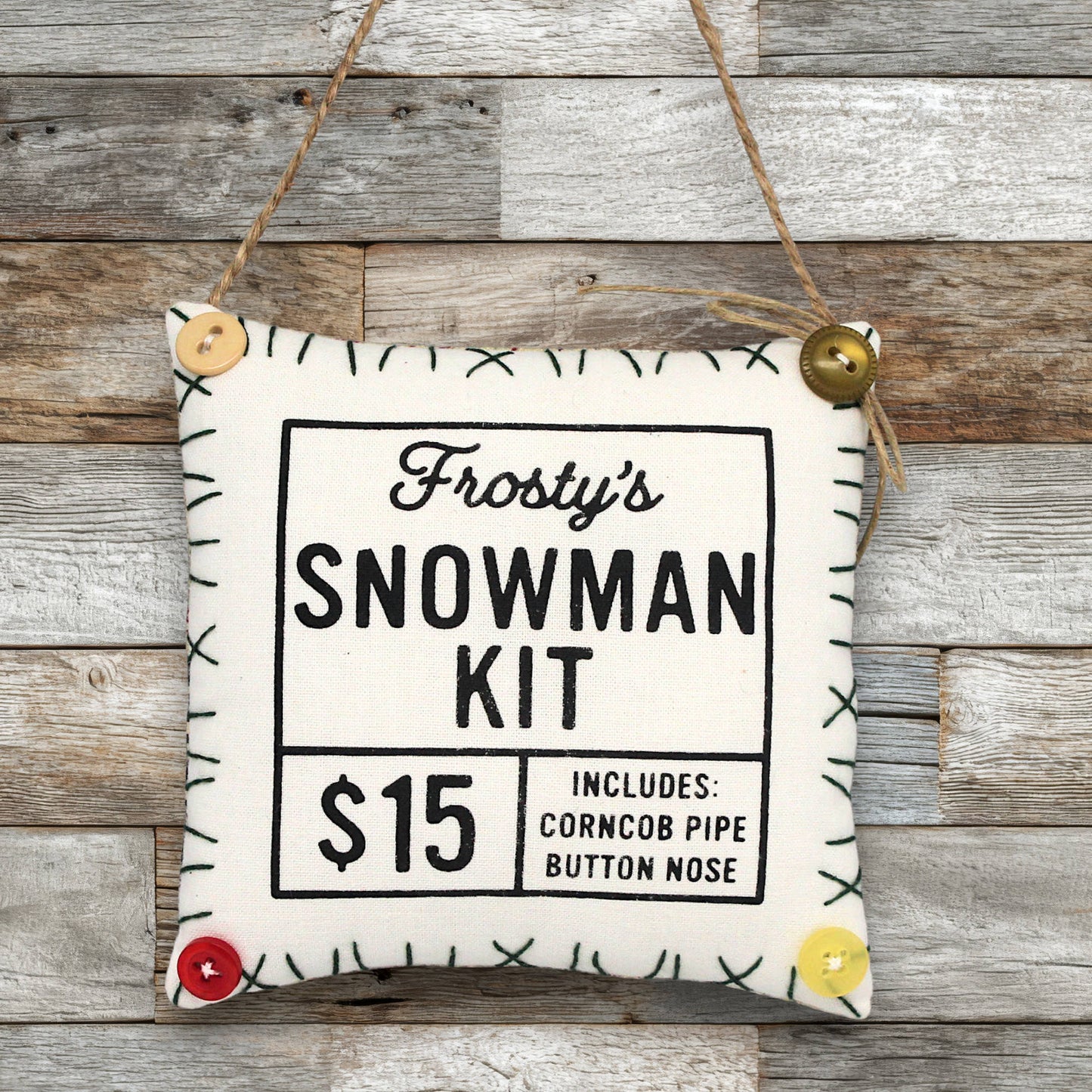 Frosty's Snowman Kit ornament sign on a wooden background