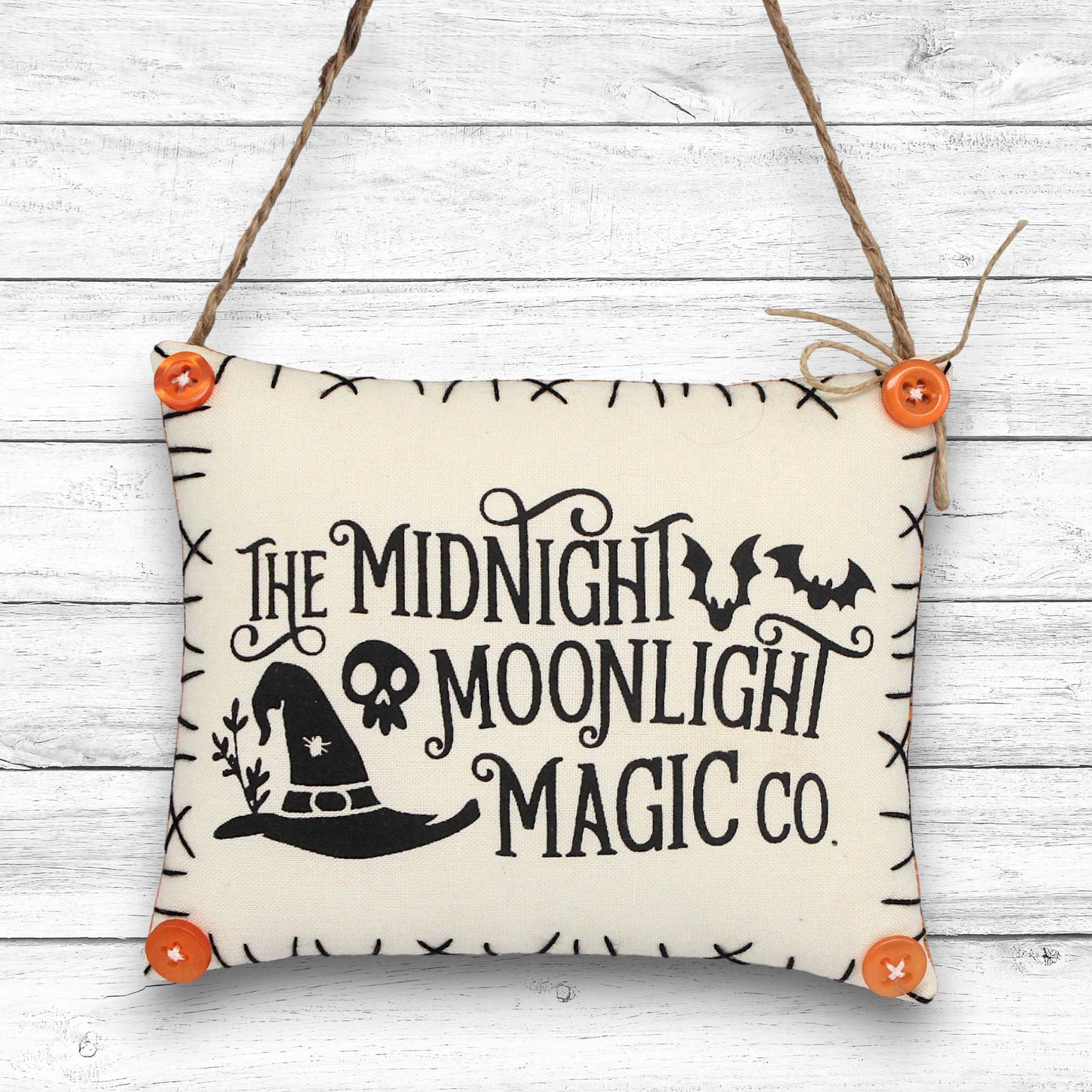 Decorative sign ornament with 'The Midnight Moonlight Magic Co.' text on a wooden background