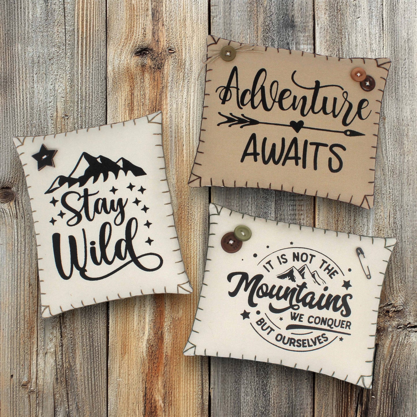 Three motivational pillows with quotes on a wooden background