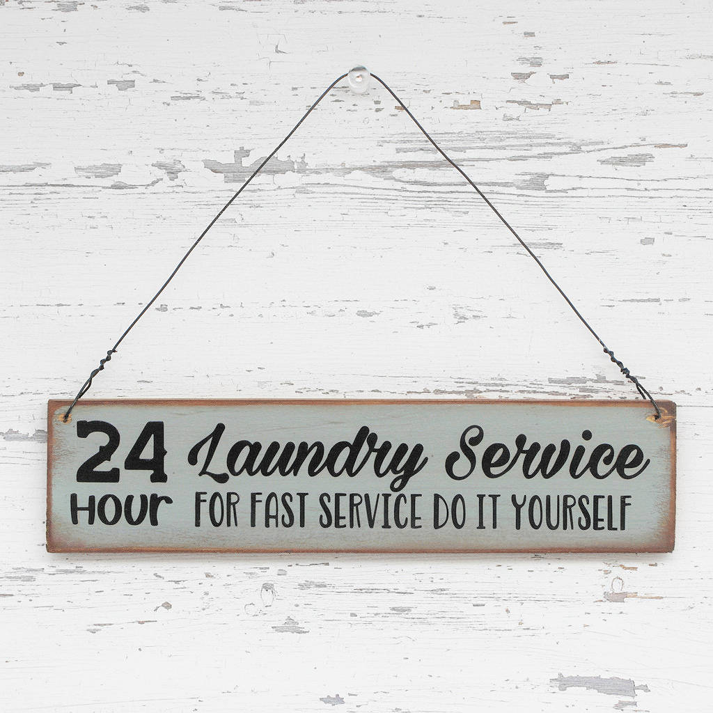 Small wooden sign that reads '24 hour laundry service, for fast service do it yourself'