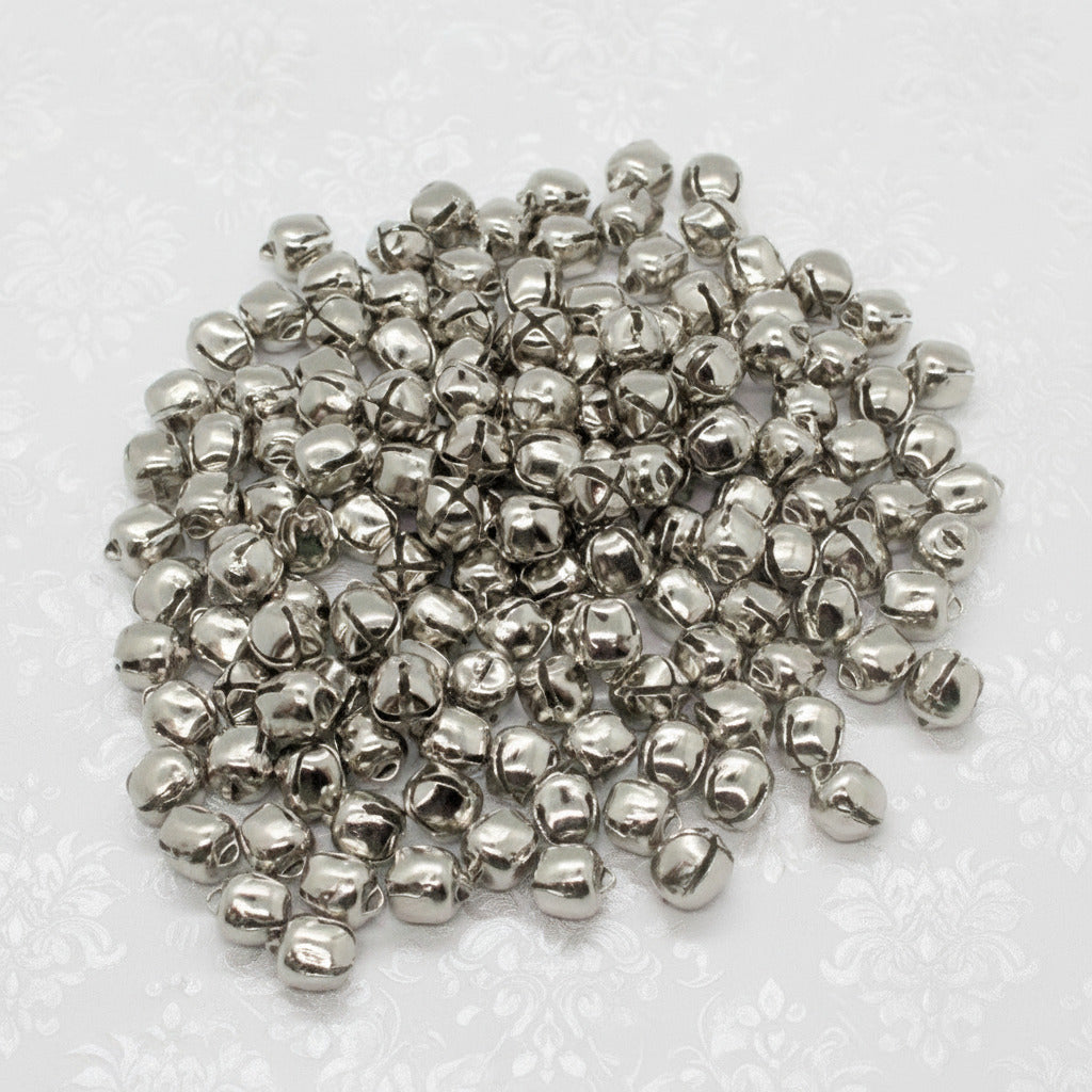 Pile of small silver bells on a white background