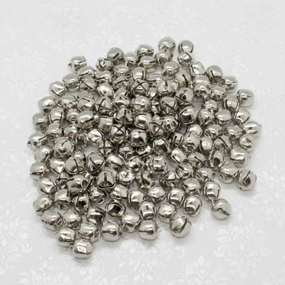 Pile of small silver bells on a white background