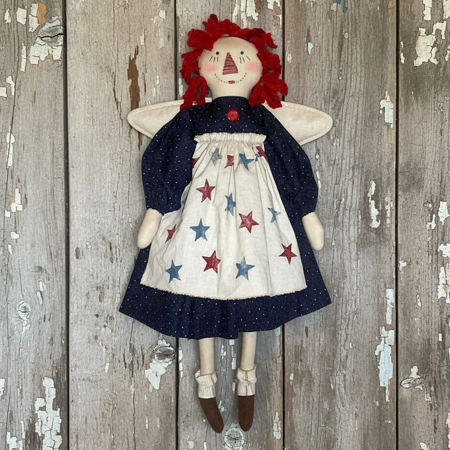 Vintage-style doll with red hair and star-patterned dress against a wooden background
