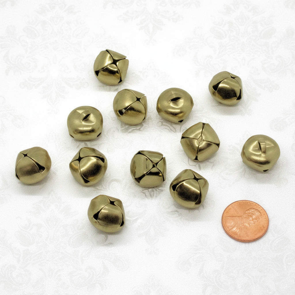 Gold toned jingle bells with a penny for scale on a white background