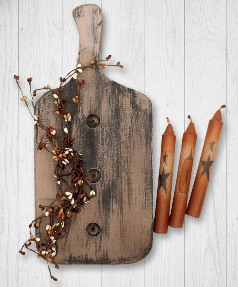 Wooden cutting board with decorative elements and candles on a white background