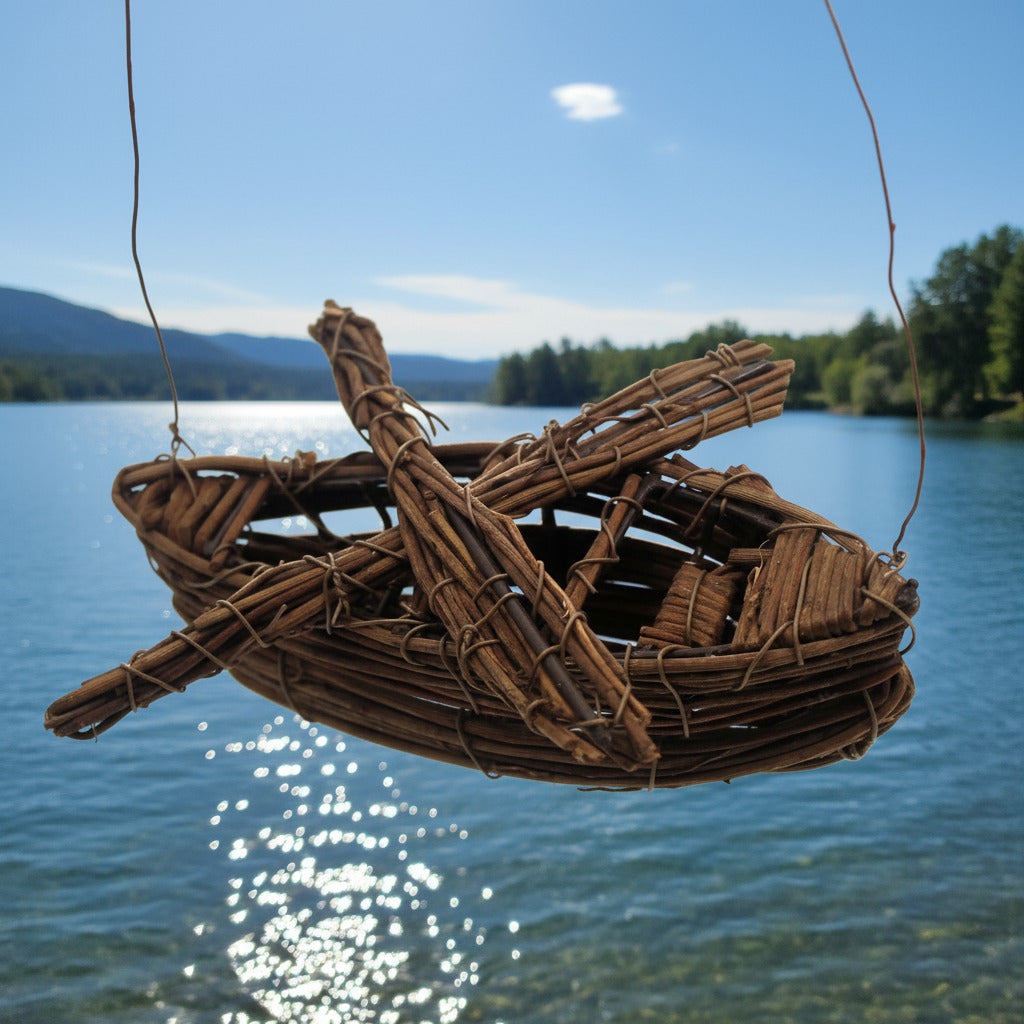 Woven boat hanging over a body of water with mountains and trees in the background