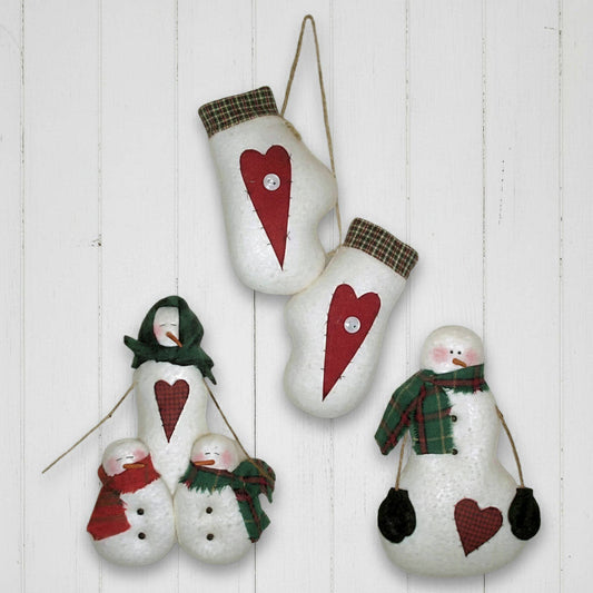 Set of Christmas-themed decorations including mittens and snowmen on a white wooden background.