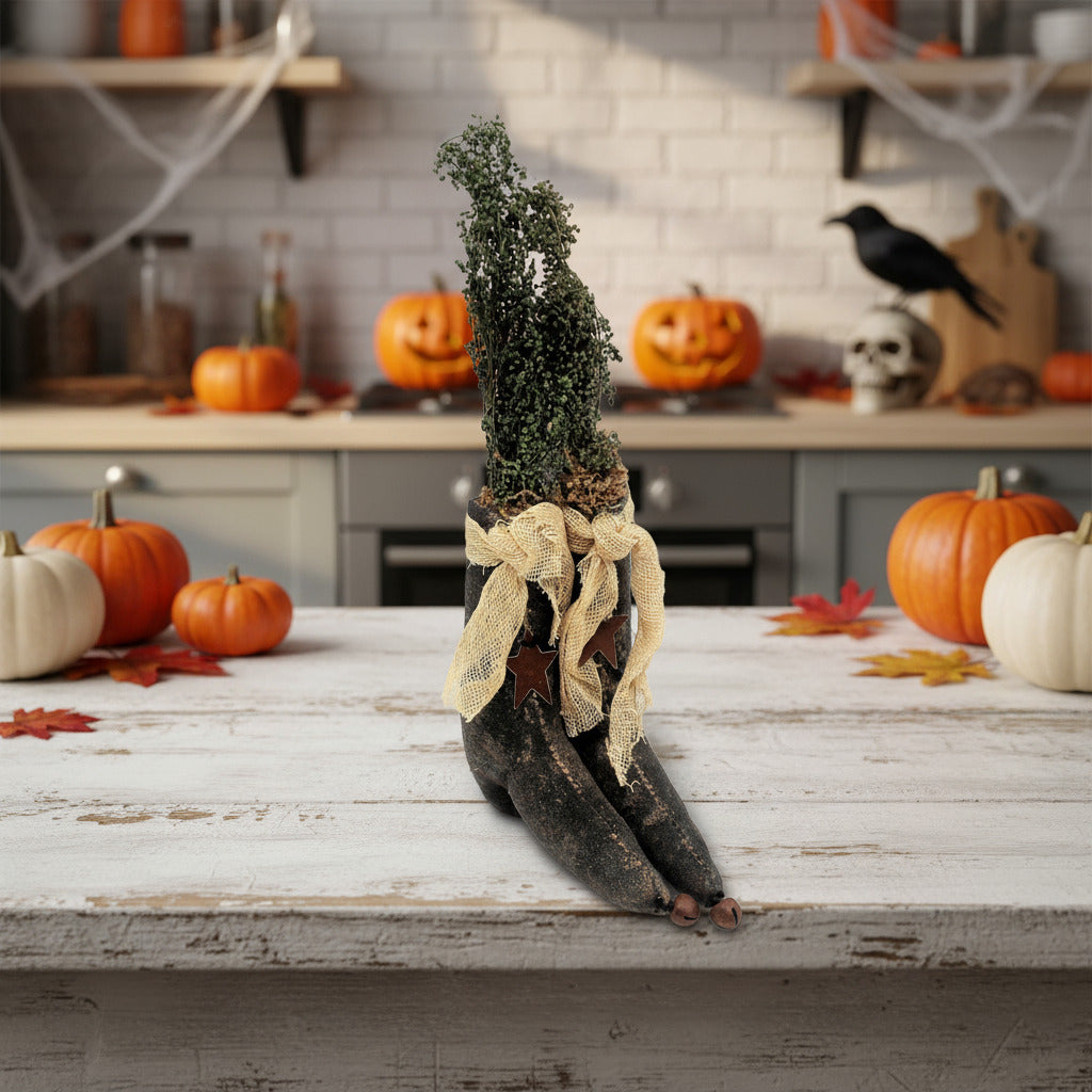Decorative tree with a bow on a table surrounded by pumpkins and Halloween decorations in a kitchen.