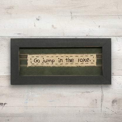 Framed text art with 'Go jump in the lake.' on a wooden background
