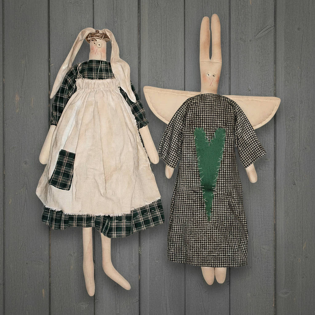 Two stuffed animal dolls with dresses against a wooden background