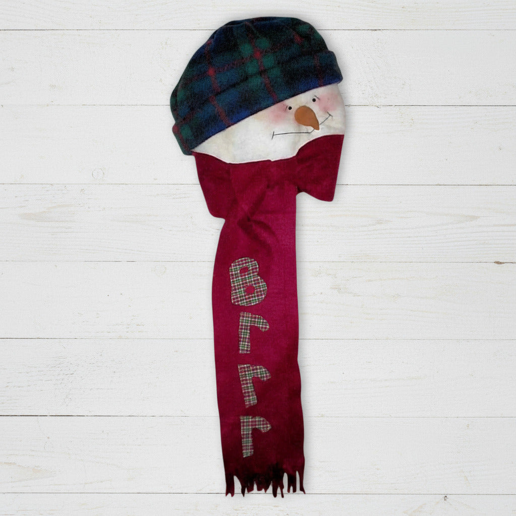 Snowman figurine wearing a blue plaid hat and red scarf with 'Brrr' text on a white background