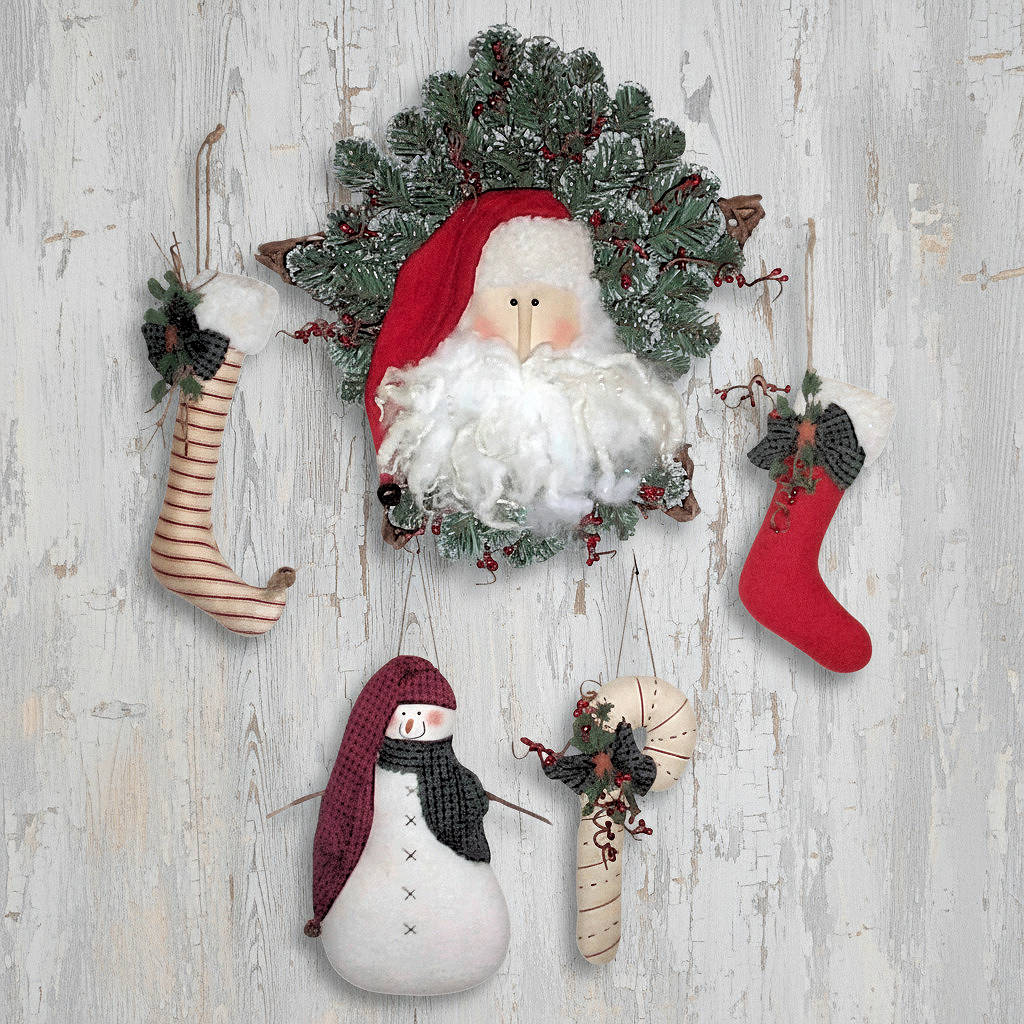 Decorative Christmas set with Santa Claus figure, wreath, snowman, and stockings on a wooden background.