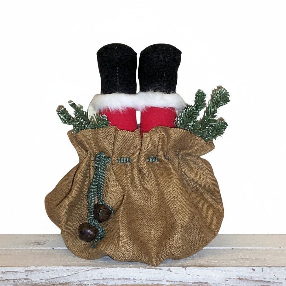 Decorative Christmas stocking with burlap bag, red socks, and greenery on a white background
