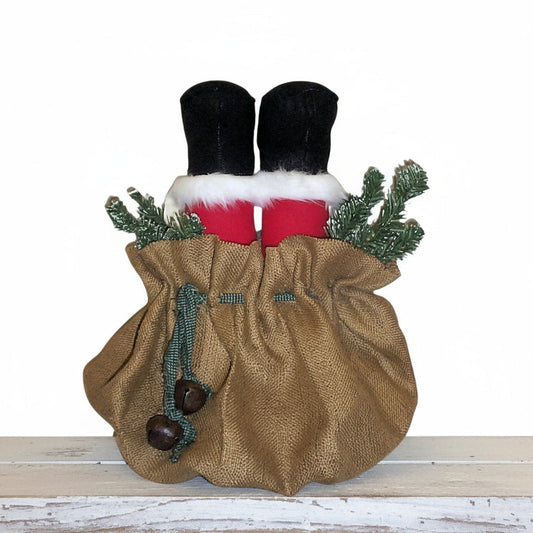 Decorative Christmas stocking with burlap bag, red socks, and greenery on a white background