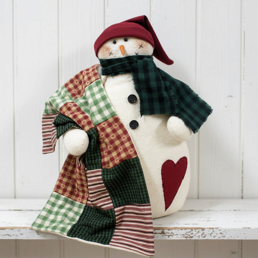Decorative snowman figurine with a patchwork coat and red hat on a white background
