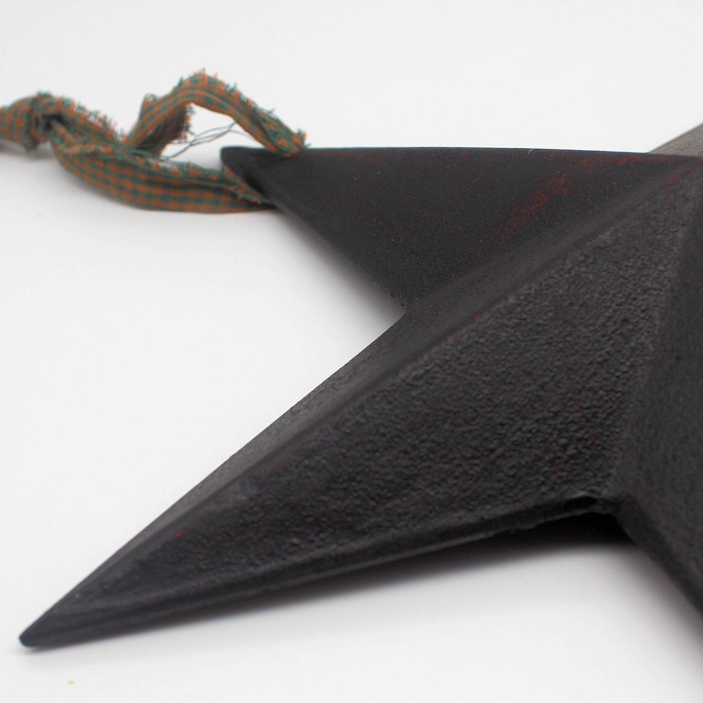 Black star-shaped object with a rope on a white background