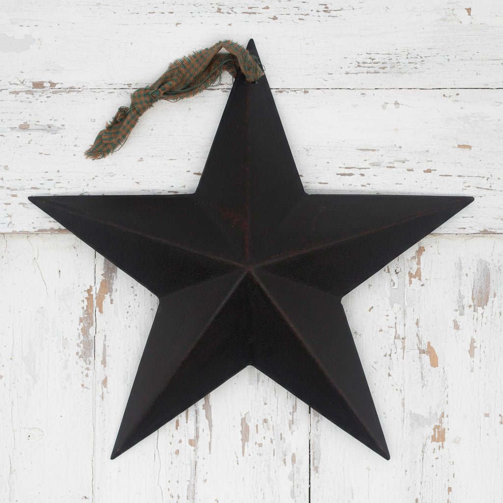 Black star-shaped wall decoration on a white wooden background