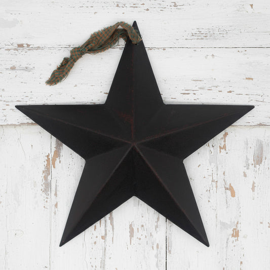 Black star-shaped wall decoration on a white wooden background
