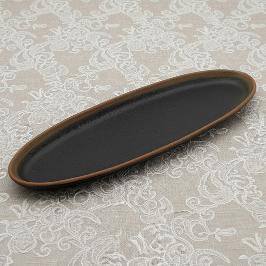Black oval tray with brown rim on a white background