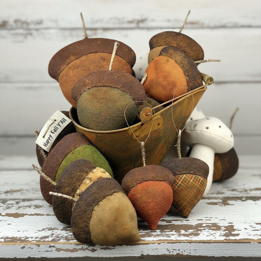 Decorative acorn ornaments with a metal bucket on a white background