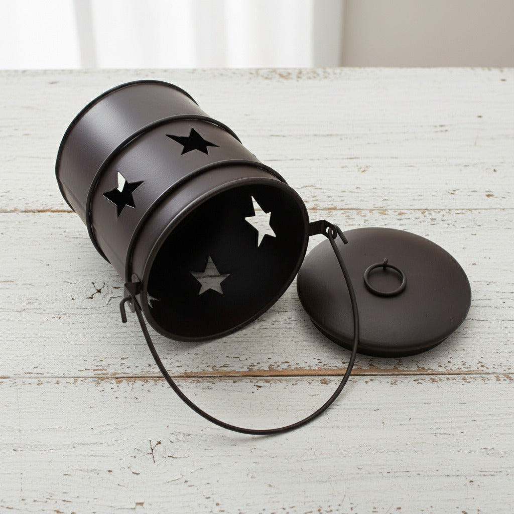 Black metal pail with star designs on a white background