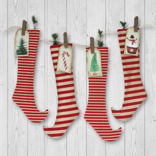 Four red and white striped Christmas stockings with festive decorations hanging on a line.