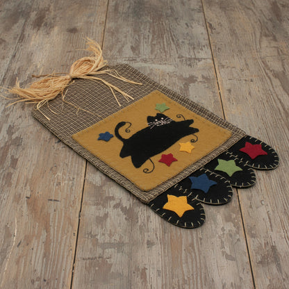 Decorative wall pocket with a black cat design on a wooden surface