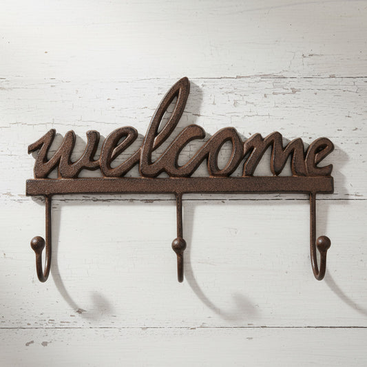 Decorative metal wall hook with 'welcome' text on a white background