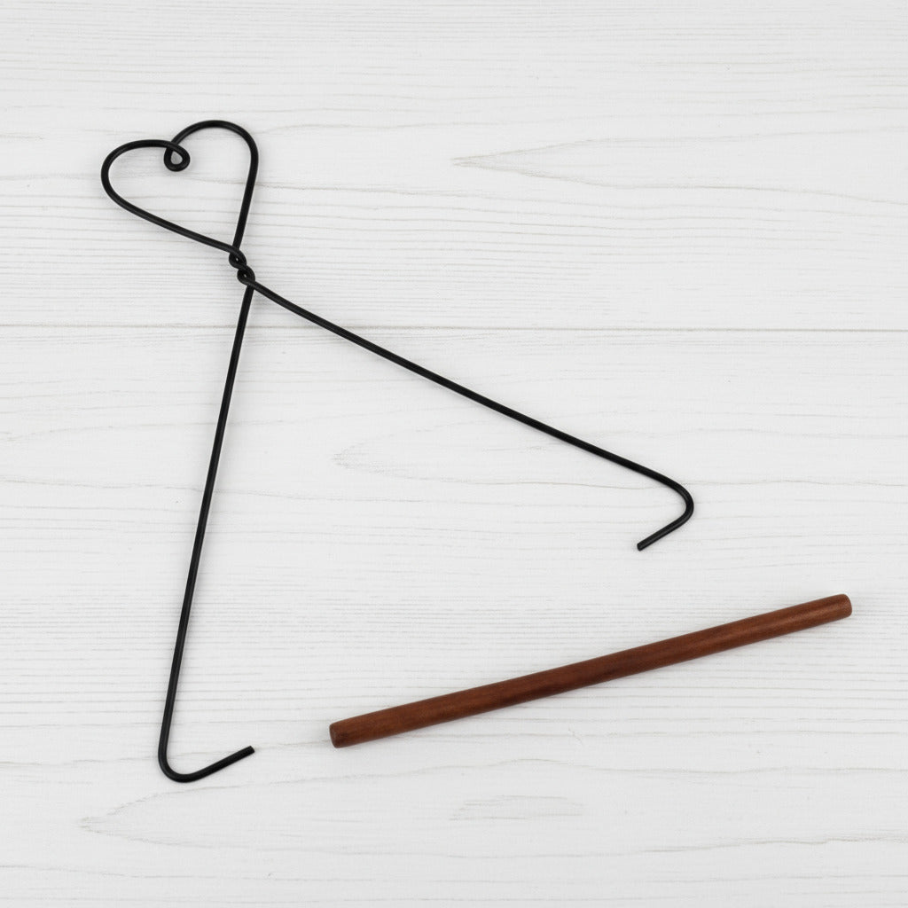 Black wire hanger with a wooden rod on a white background