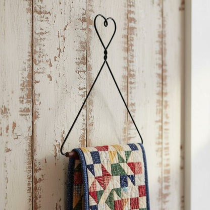 Black metal triangle-shaped hook with a heart at the top on a white background