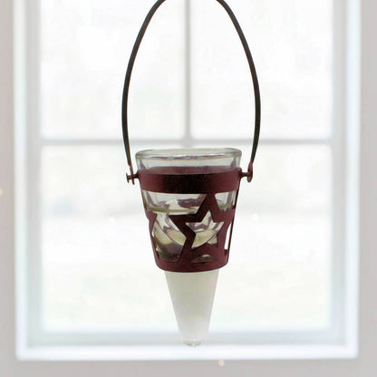Decorative hanging tea light holder with star design in front of a window