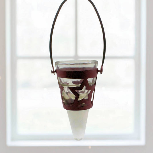 Decorative hanging tea light holder with star design in front of a window