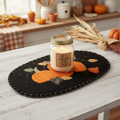 Decorative black oval mat with orange pumpkins and autumn leaves