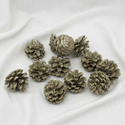 Decorative pinecones with a glittery metallic finish on a white background