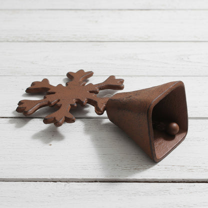 Brown metal bell with snowflake design on a white background