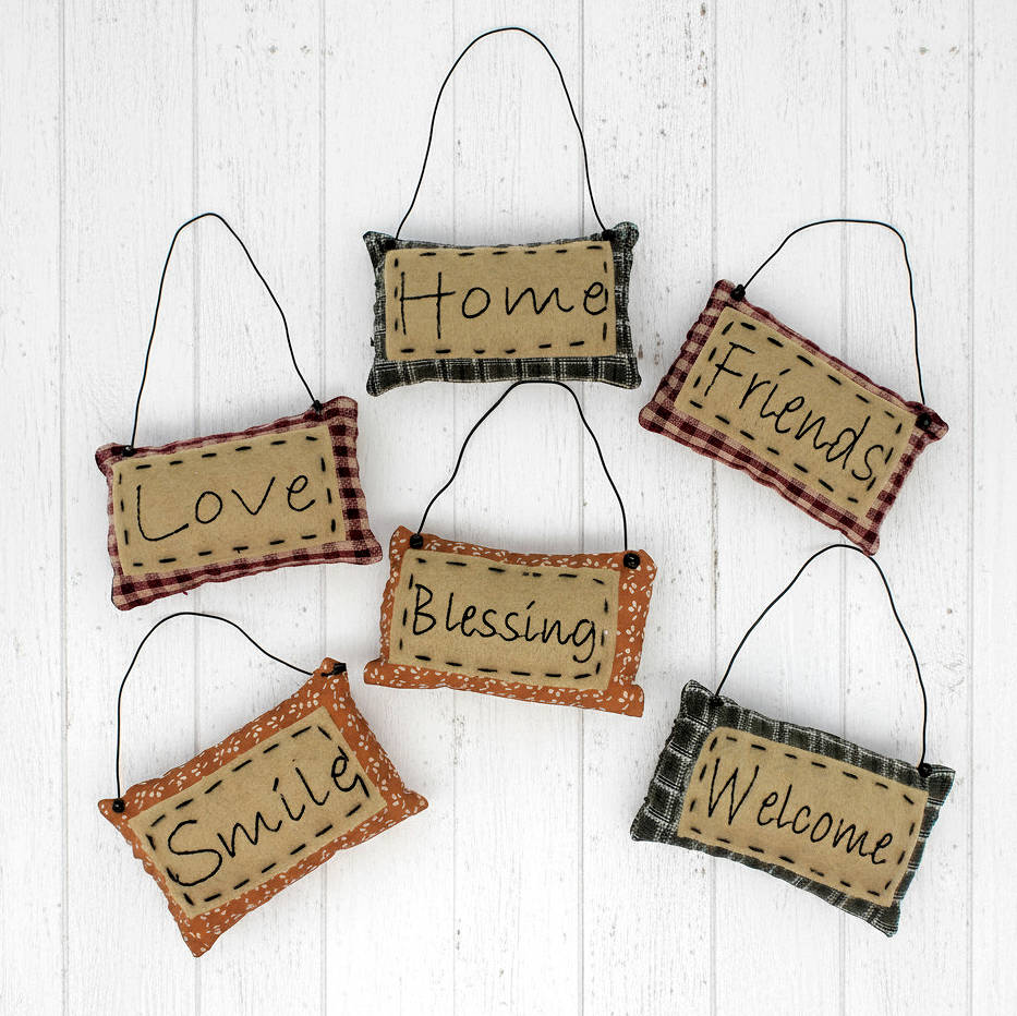 Set of hanging fabric signs with motivational phrases on a white wooden background