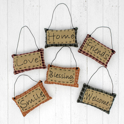 Set of hanging fabric signs with motivational phrases on a white wooden background