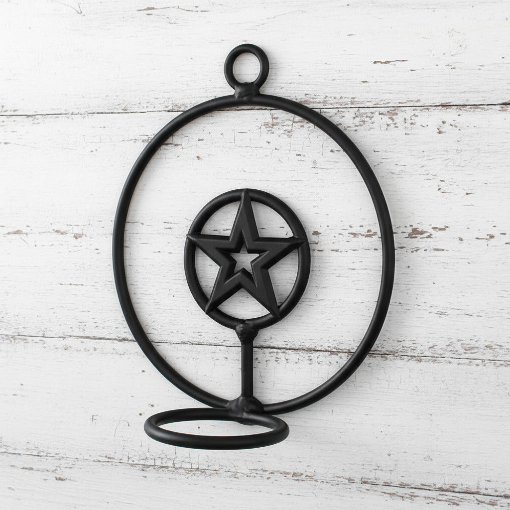 Black metal candle holder with star design on a white background