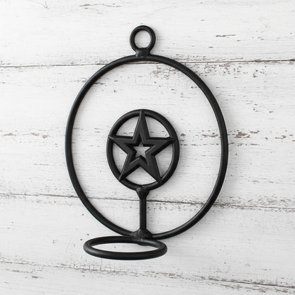 Black metal candle holder with star design on a white background