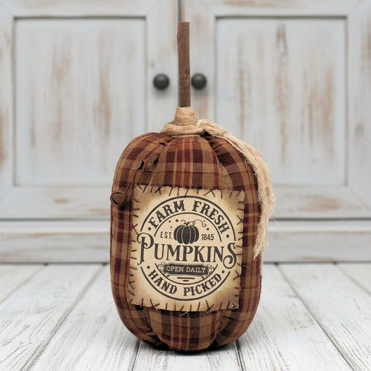Decorative grungy fabric pumpkin with 'Farm Fresh Pumpkins' label on a white background