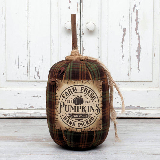 Decorative grungy fabric pumpkin with 'Farm Fresh Pumpkins' label on a wooden surface.