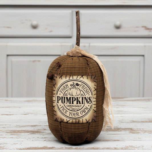 Decorative grungy homespun pumpkin with a rustic label on a wooden surface
